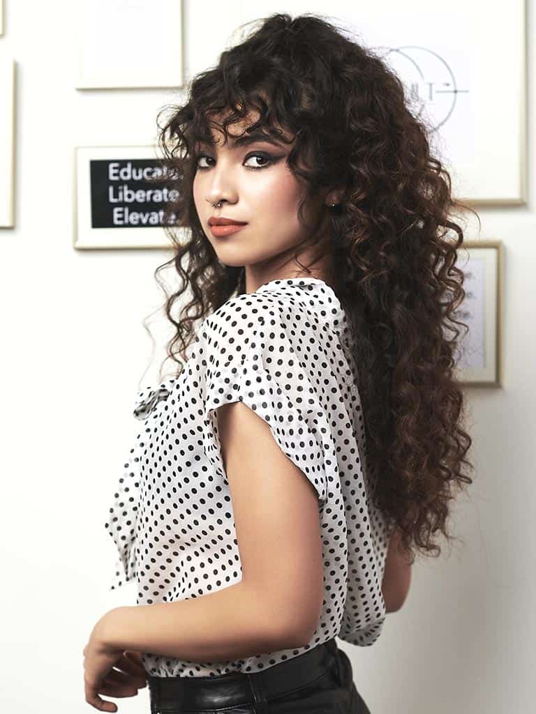 Woman posing for a photo showing off her Curl Cult perm